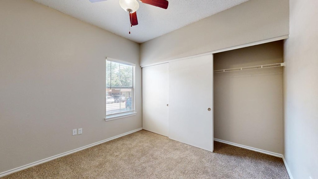 an empty bedroom with a closet and a window at Southgate Glen, Weatherford, 76086