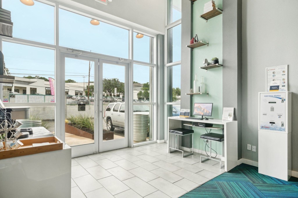 a lobby with large windows and a desk with a computer