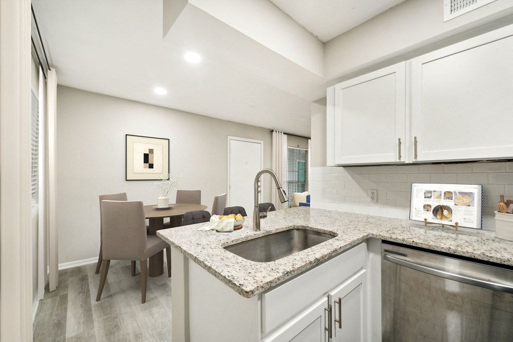 a kitchen with a sink and a table with chairs