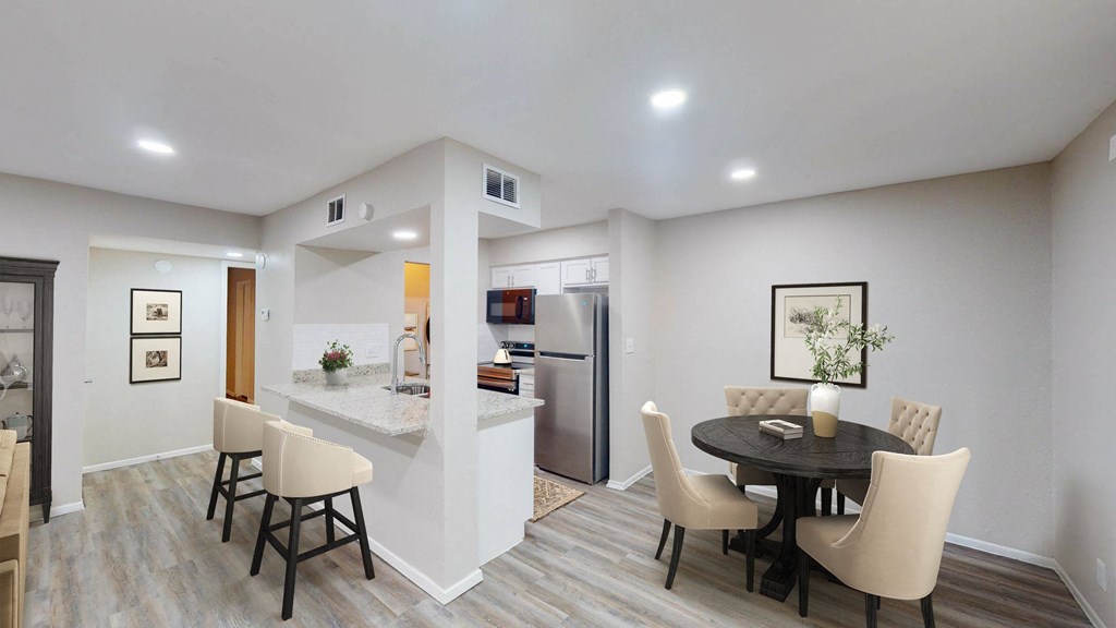 a dining area with a table and chairs and a kitchen in the background at The Frederick, San Antonio, TX