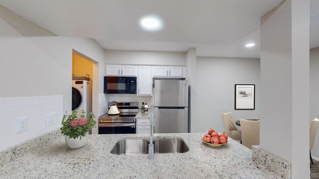a kitchen with granite countertops and stainless steel appliances at The Frederick, San Antonio, TX