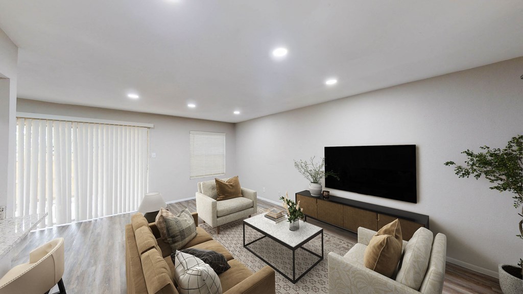 a living room with white walls and a flat screen tv on the wall at The Frederick, San Antonio, TX