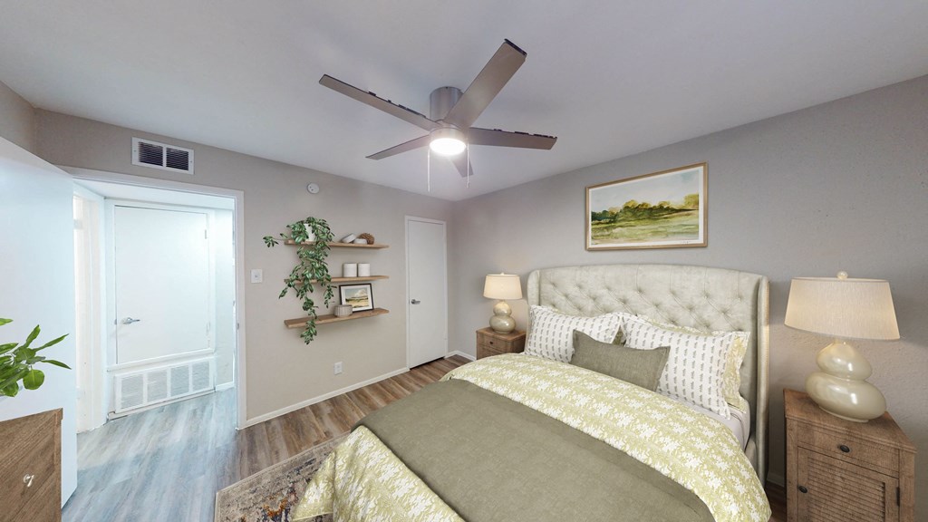 a bedroom with a ceiling fan and a bed with a yellow and white comforter at The Frederick, San Antonio