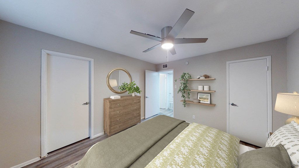 a bedroom with a ceiling fan and a bed with a yellow and white comforter at The Frederick, San Antonio Texas