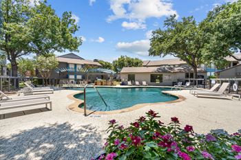 a pool with lounge chairs and trees in the background  at Vesper, Dallas, 75254
