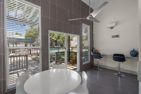 a dining area with a white table and chairs and a sliding glass door that leads to a  at Vesper, Dallas