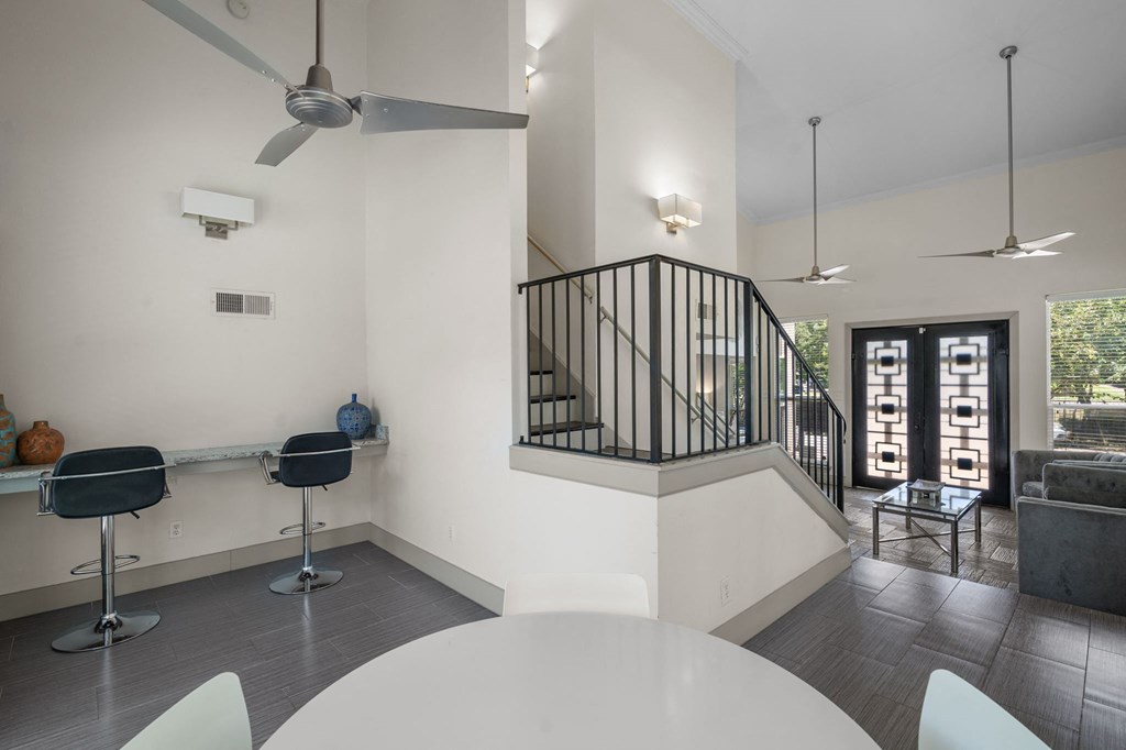 a living room with white walls and a staircase with black railings  at Vesper, Dallas