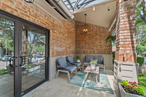 A patio with a glass door and a brick wall.