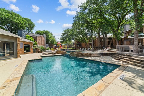 A swimming pool surrounded by a stone border.