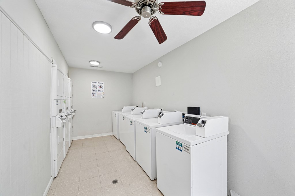 A laundry room with a fan and washing machines.