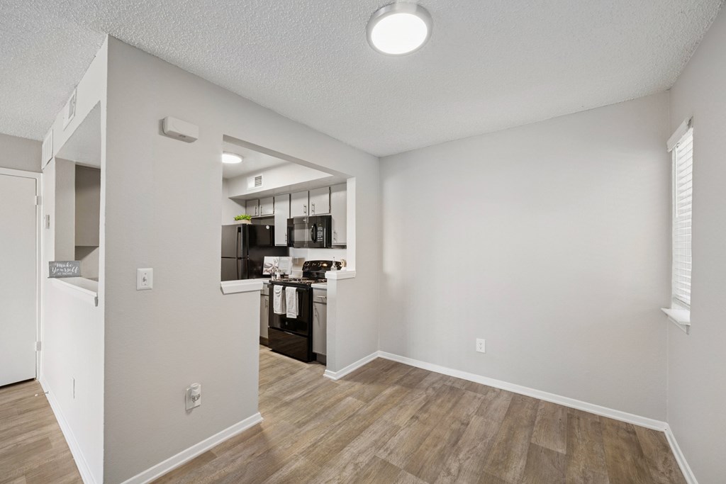 A kitchen area with a refrigerator, sink, and cabinets.