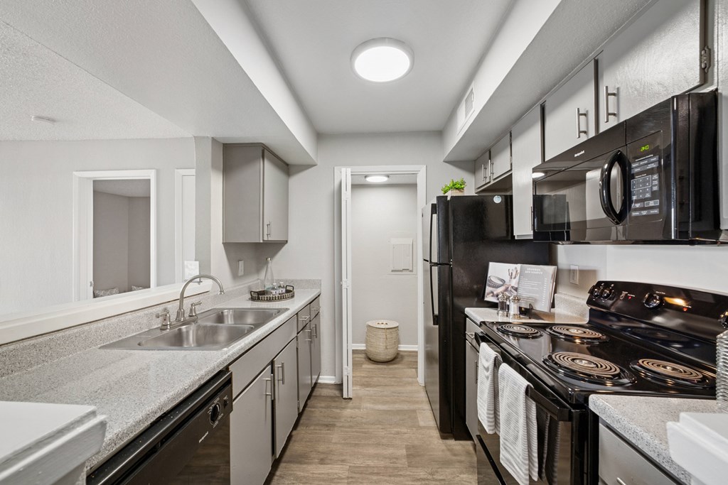 A modern kitchen with black appliances and white cabinetry.