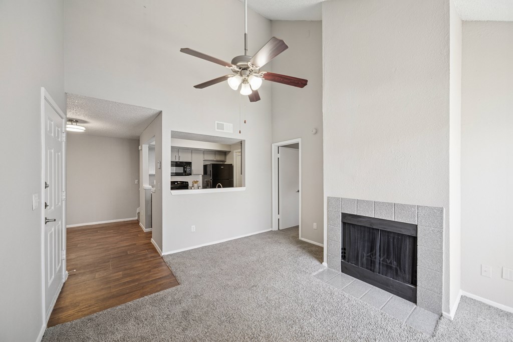 A living room with a fireplace and a ceiling fan.