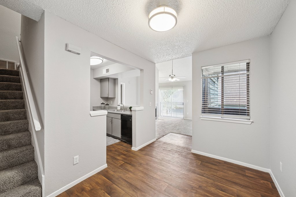 A kitchen area with a staircase on the left side.