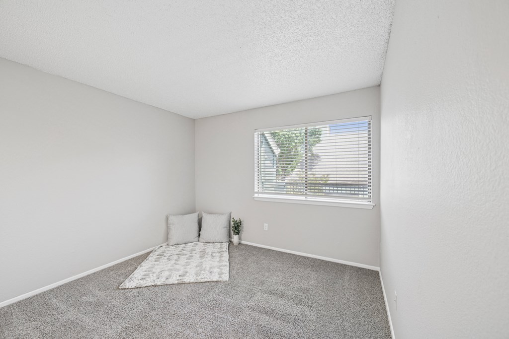 A bedroom with a window and a bed.