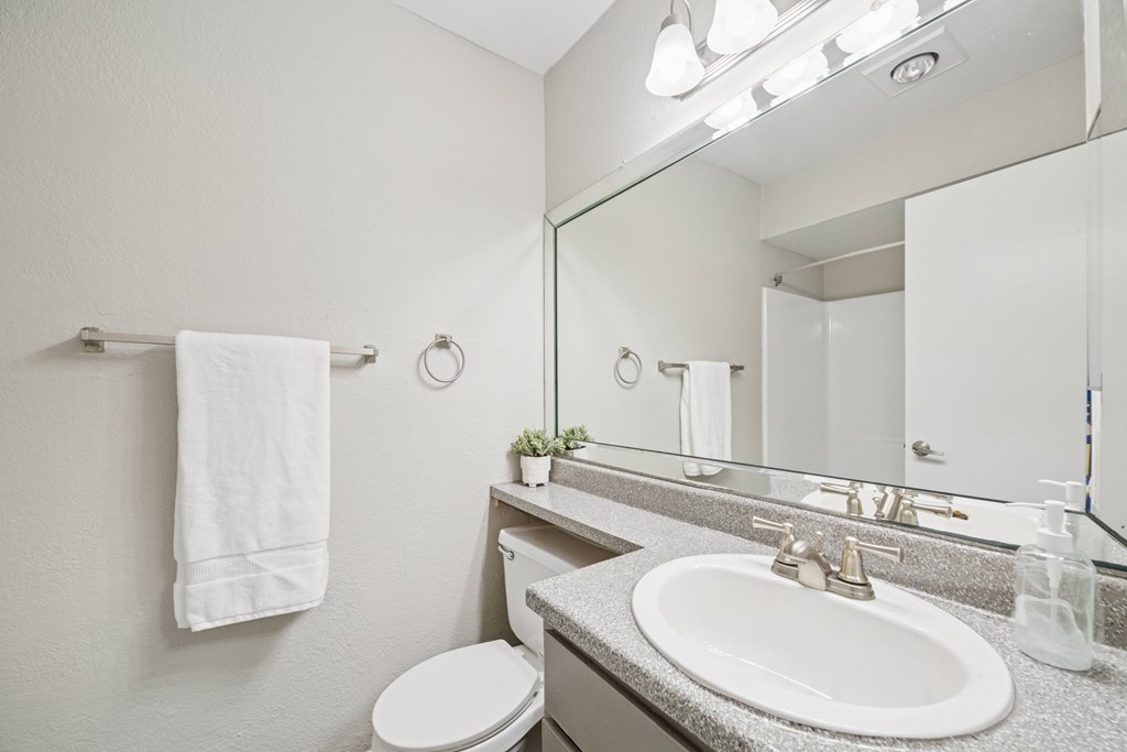 A white towel hangs on a towel rack in a bathroom.