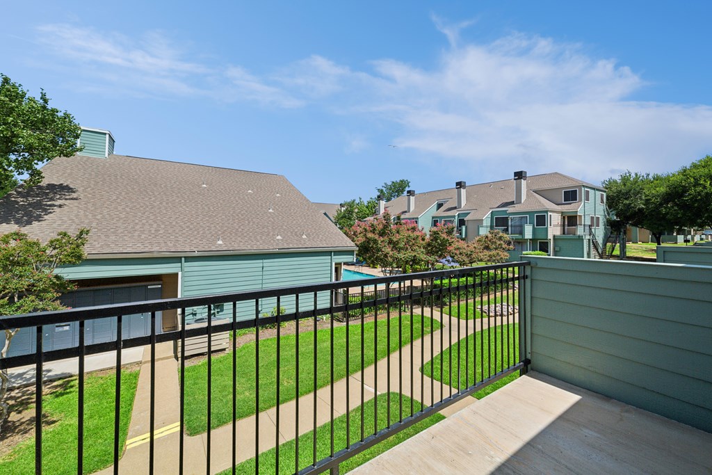 A house with a green roof and a black fence.