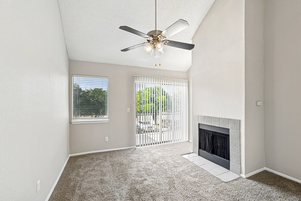 A room with a fireplace and a ceiling fan.