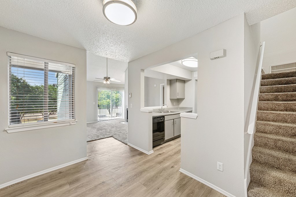A spacious living room with a staircase leading to the upper floor.