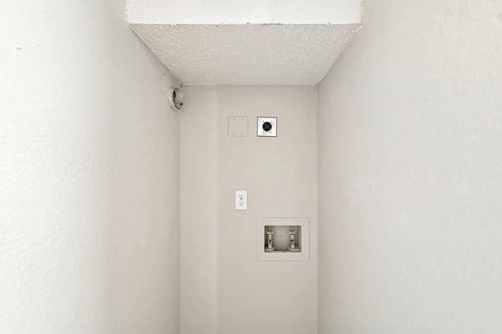 A white wall with a switch and a socket.