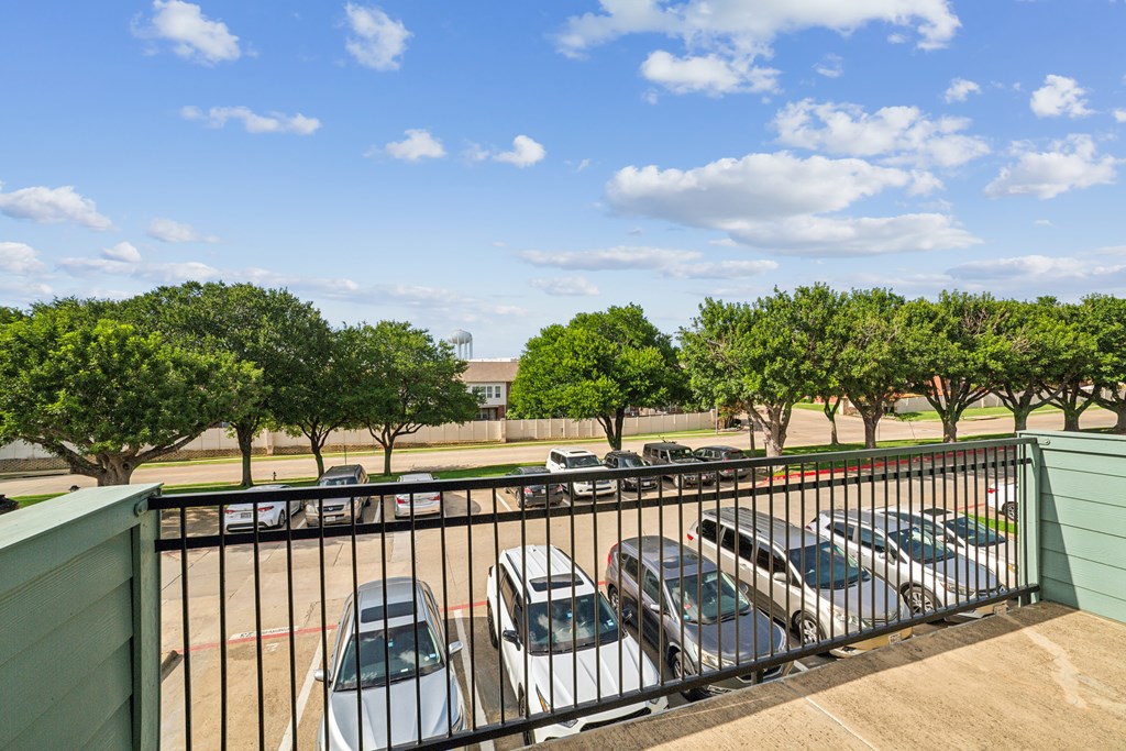 A parking lot with cars and trees.