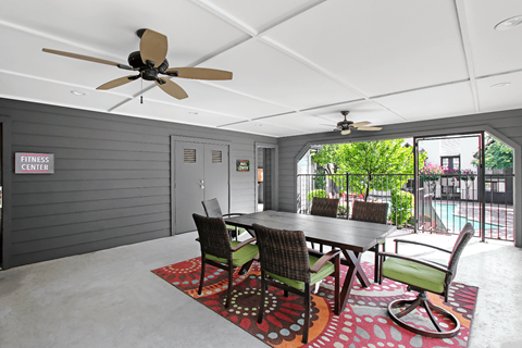 A dining room with a table and chairs and a ceiling fan.