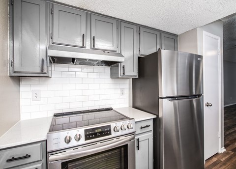 A kitchen with a stove, oven, and refrigerator.
