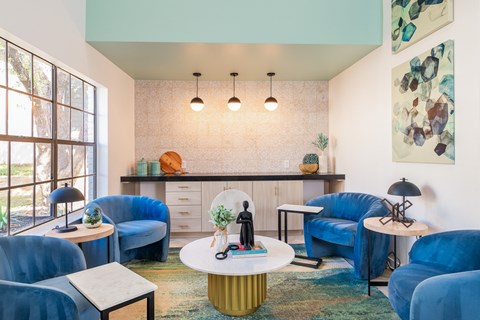 A living room with blue chairs and a white coffee table.