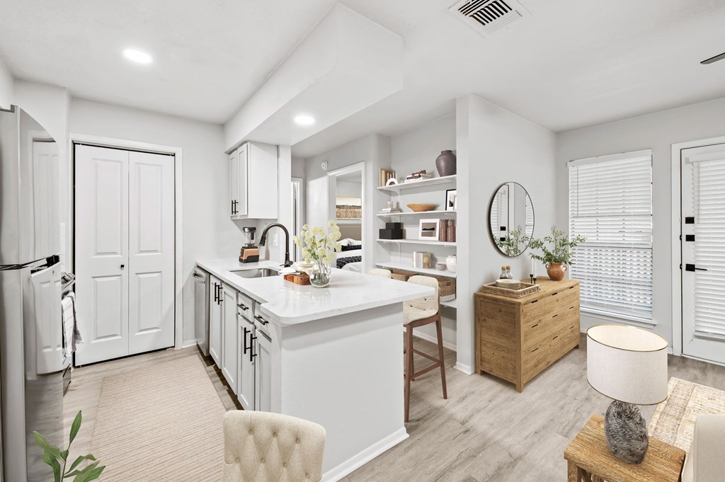 a kitchen and living room with white walls and a wooden floor  at Carmel at Deerfield, San Antonio, TX