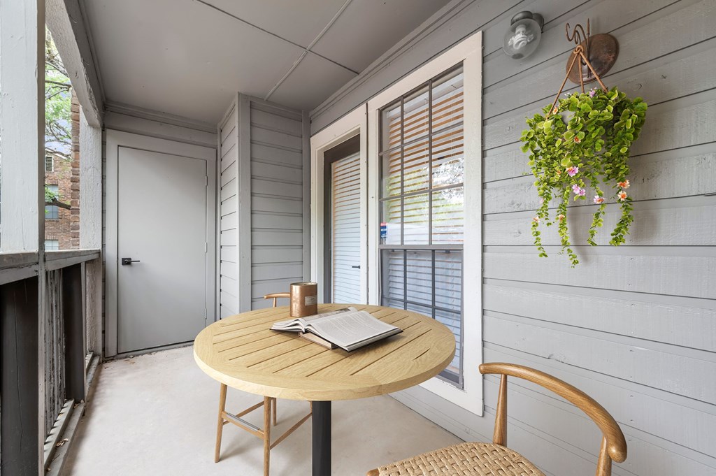 a small table with a cup of coffee and a book on it on the balcony at Carmel at Deerfield, Texas