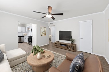 a living room with a ceiling fan and a coffee table in the middle of the room