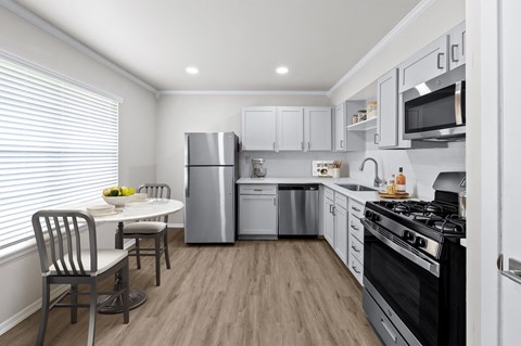 a kitchen with white cabinetry and stainless steel appliances a kitchen with white cabinetry and stainless steel appliances at Sunset Heights, San Antonio, TX, 78209