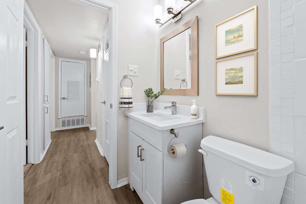 a bathroom with a white toilet next to a white sink with a mirror above it  at Sunset Heights, Texas, 78209
