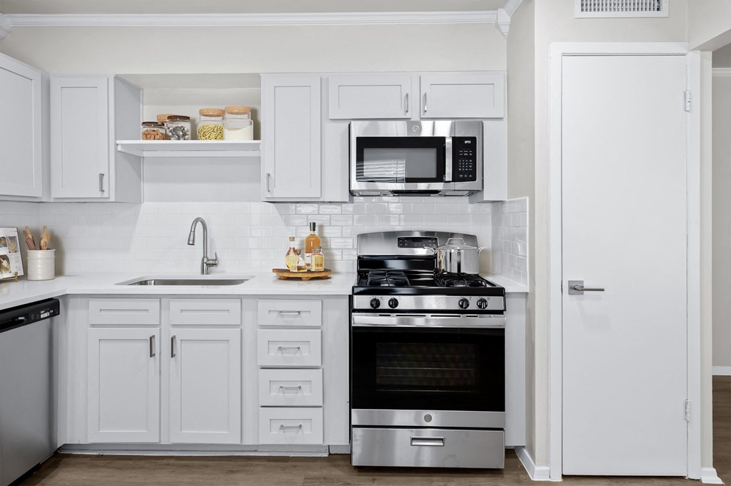a kitchen with white cabinets and stainless steel appliances  at Sunset Heights, San Antonio