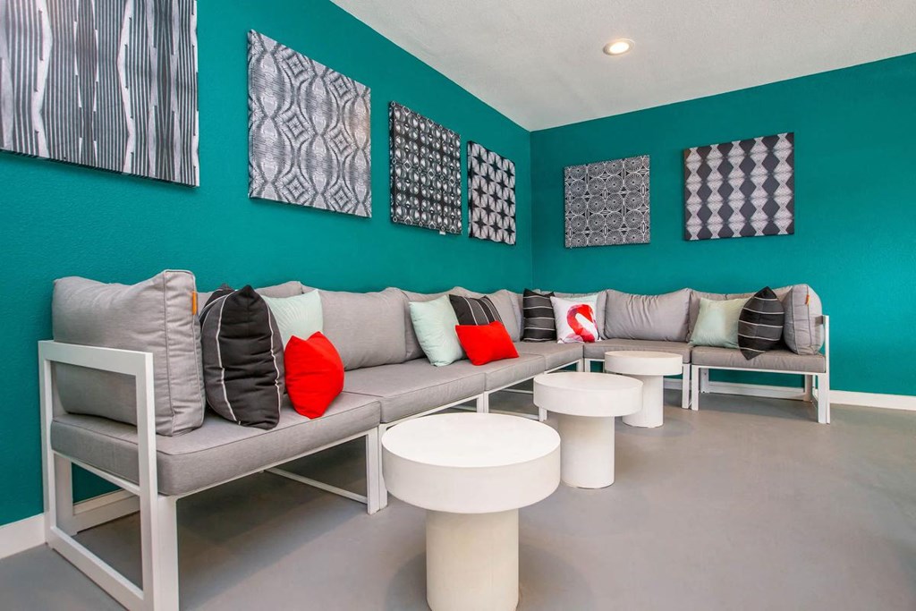 a waiting room with couches and chairs and paintings on the wall