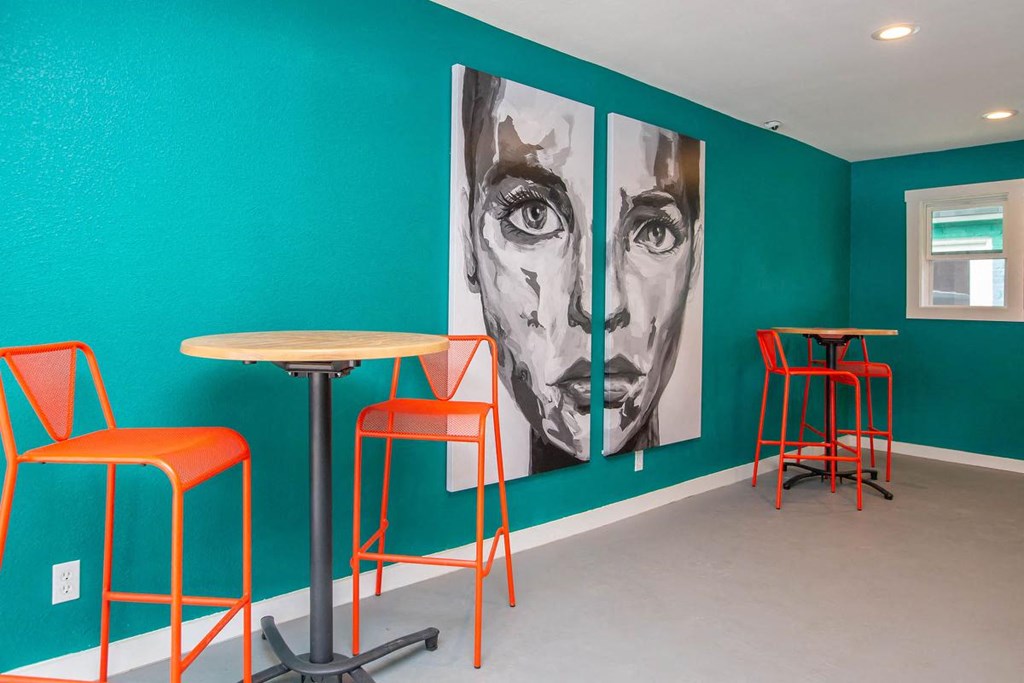 a room with tables and chairs and paintings on the wall