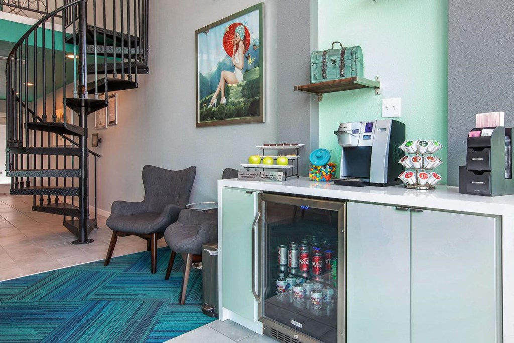 a hotel room with a counter with drinks and a spiral staircase