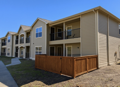 A row of houses with a wooden fence in front.