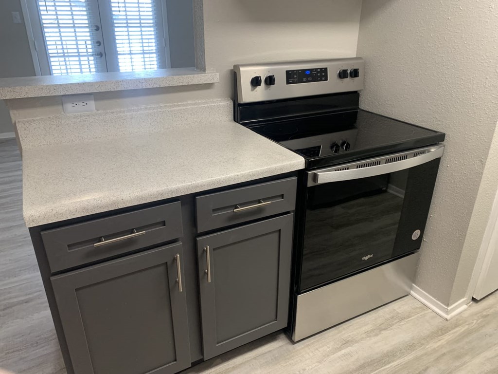 a kitchen with a stove top oven next to a window