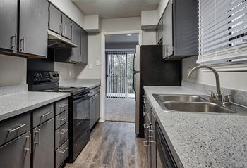 a kitchen with granite counter tops and stainless steel appliances at The Broadwater at Salado Creek, San Antonio, Texas