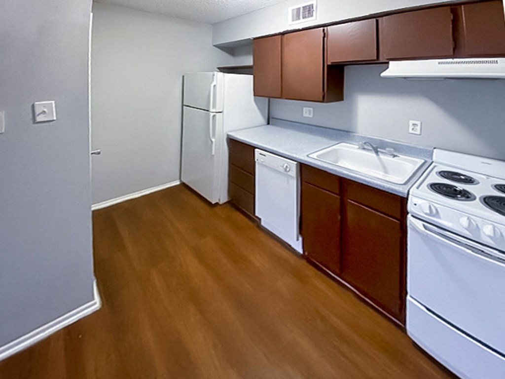 a kitchen with white appliances and brown cabinets at The Frederick, Texas
