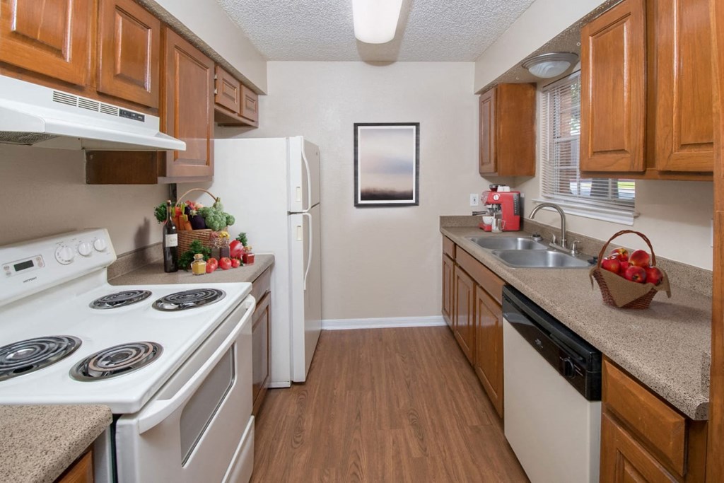a kitchen with white appliances and wooden cabinets at Tradewinds, Texas, 78239
