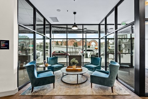 a lounge area with blue chairs and a table