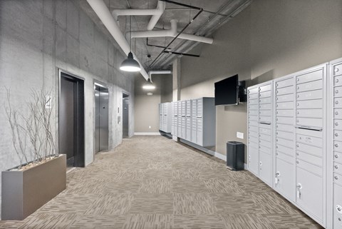 a row of lockers in a room with a hallway and a television