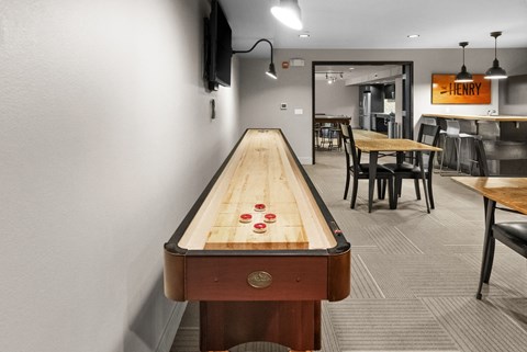 a foosball table in a game room with a dining area and a bar