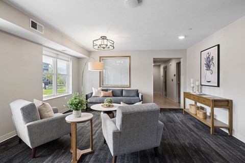 A living room with grey chairs and a grey couch.