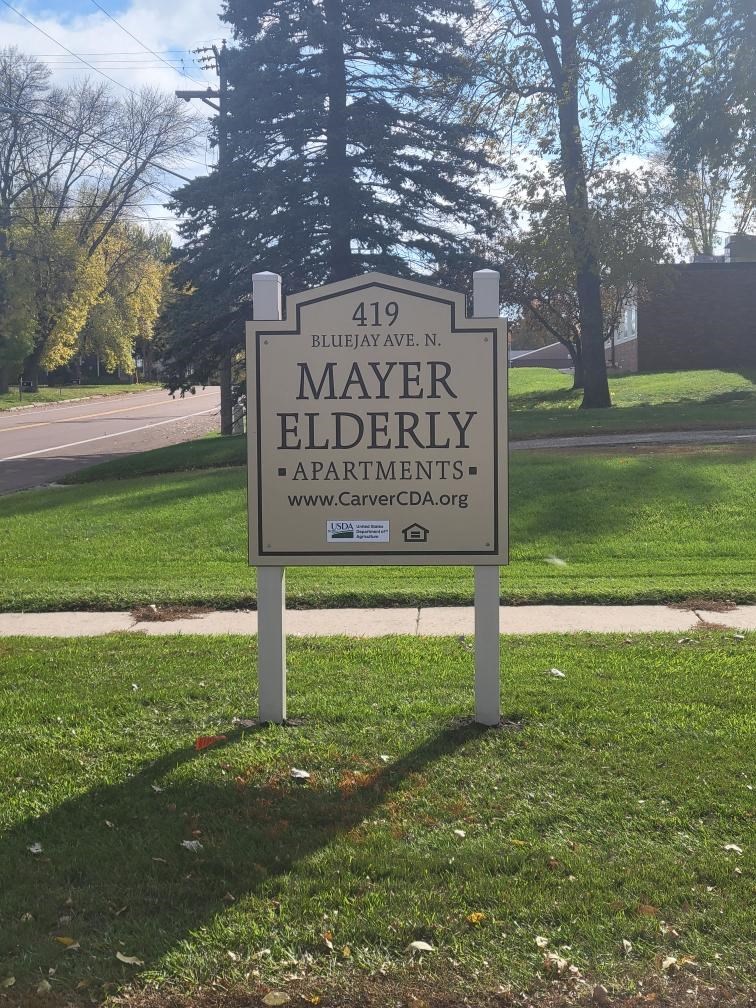 a sign in the grass in front of a cemetery