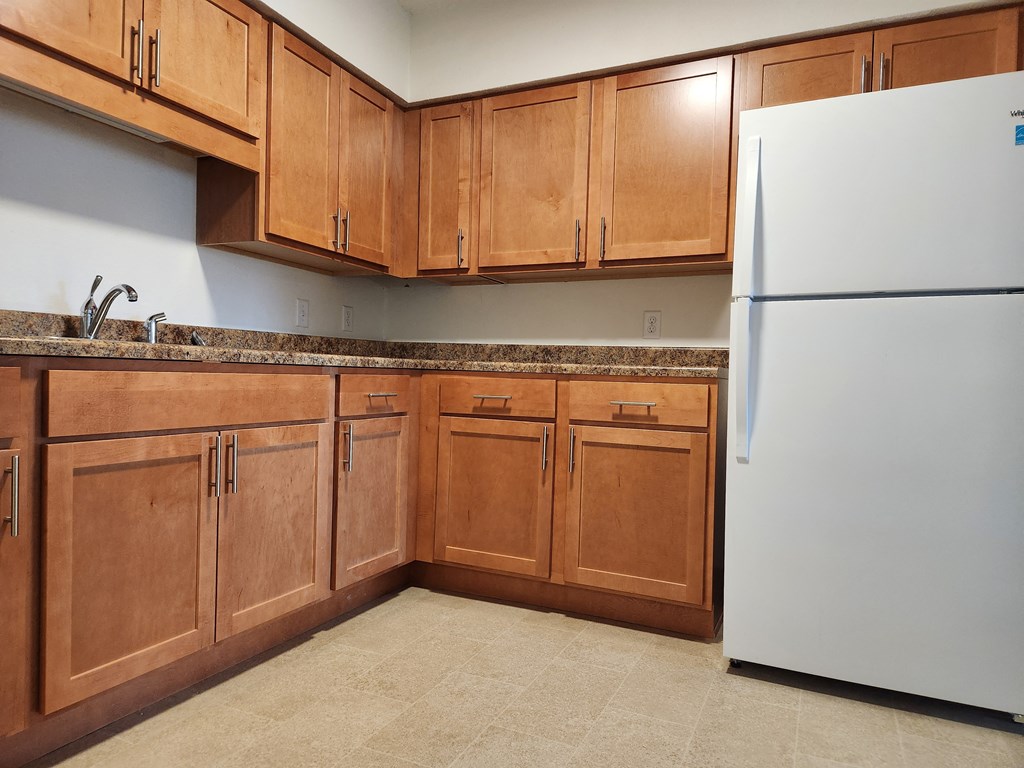 a kitchen with wooden cabinets and a white refrigerator
