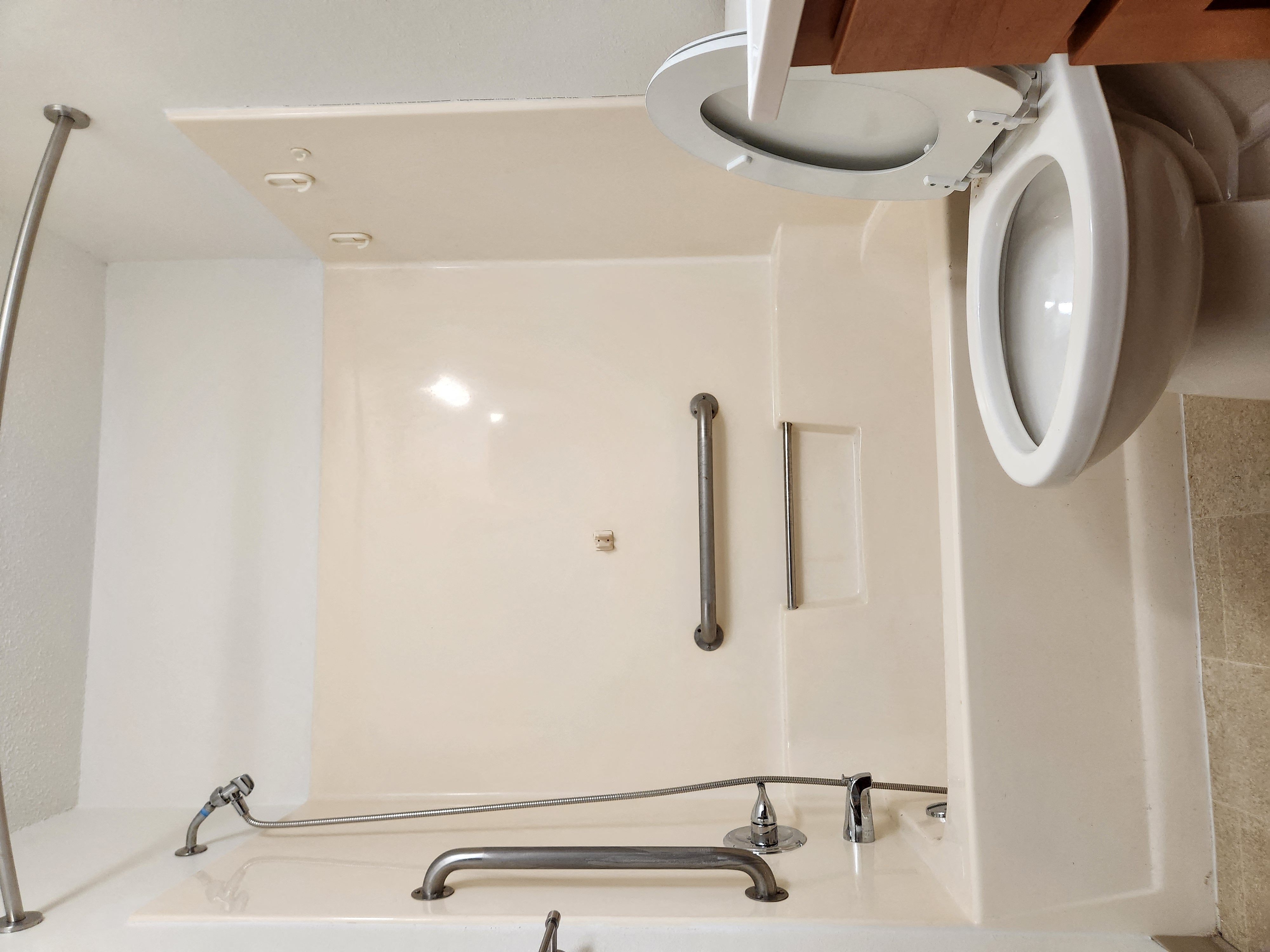 a white bathroom with a urinal and a sink and a mirror