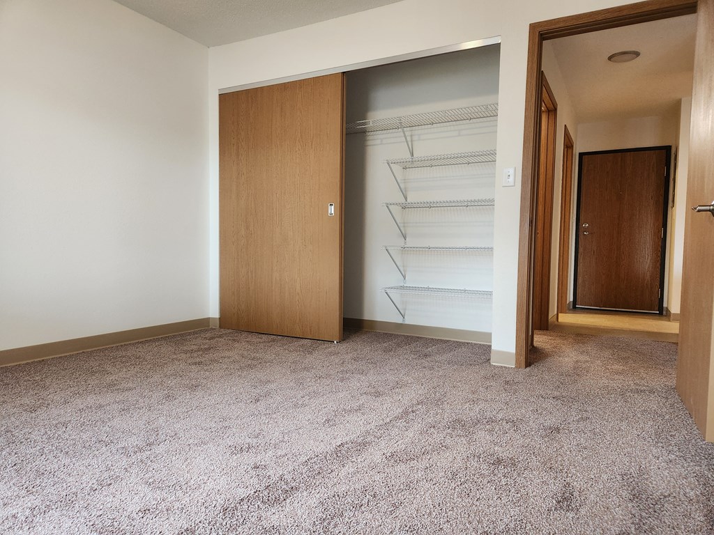 an empty room with a closet and a door